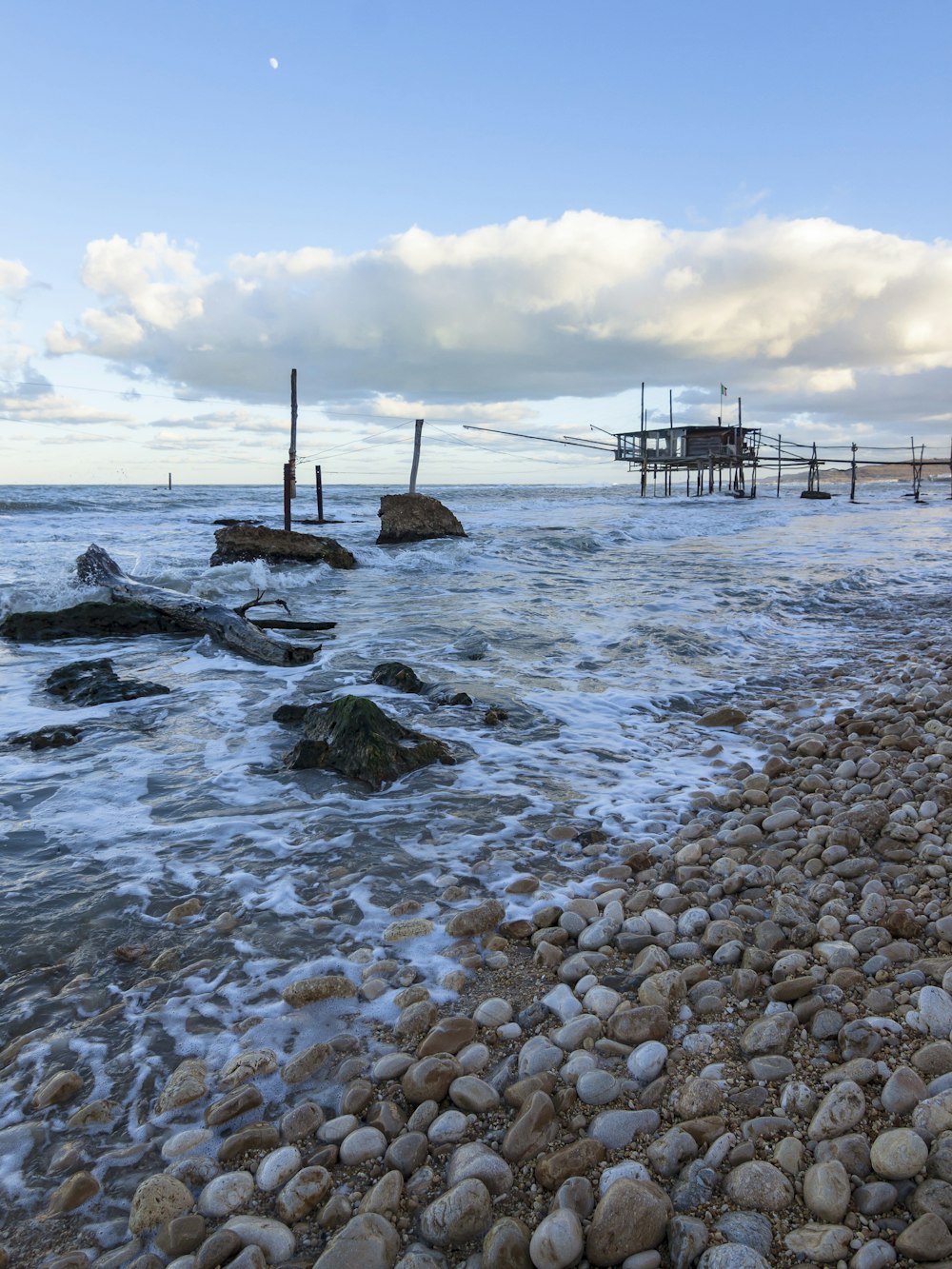 brown wooden dock on sea under blue sky during daytime