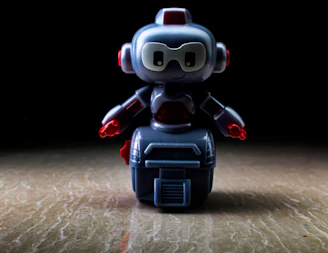 A sleek, modern toy robot glowing softly with blue LED lights on a clean white background