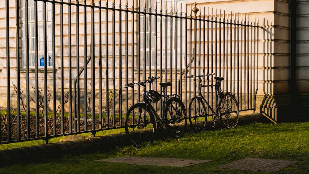 black bicycle parked beside black metal fence during daytime