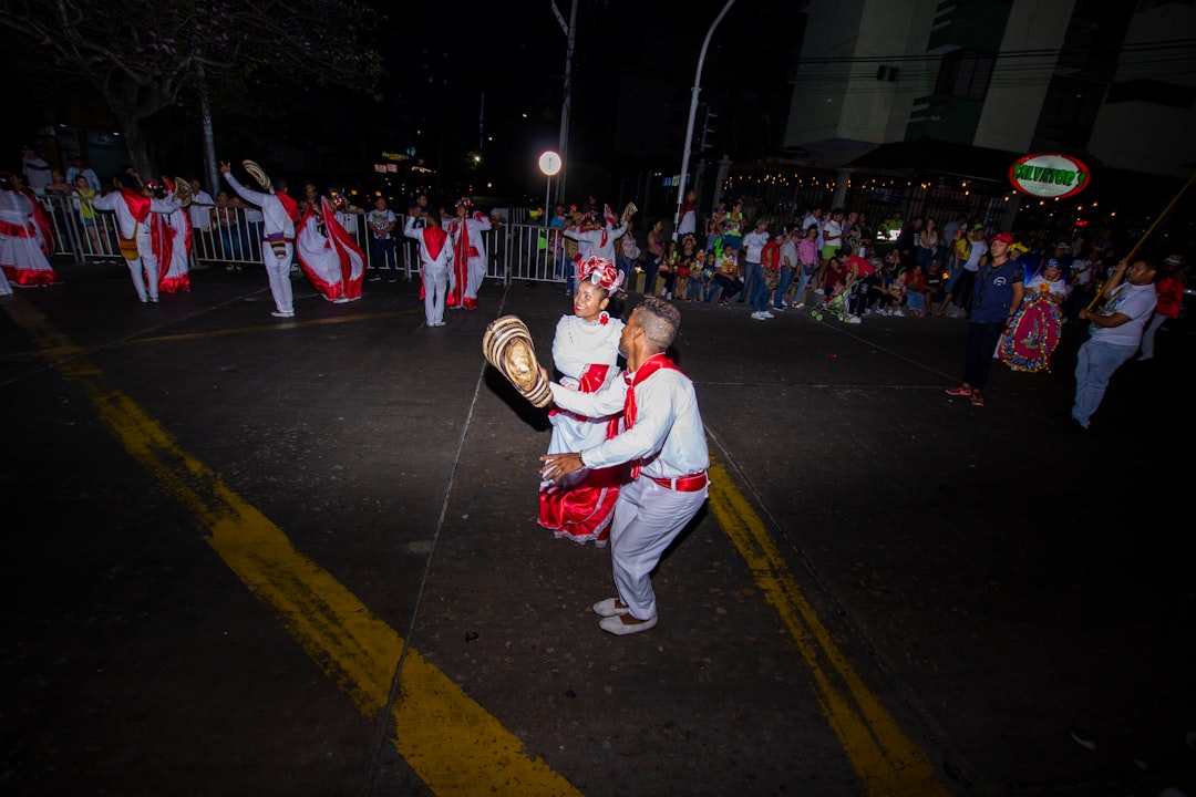 man in white and red costume standing on road during nighttime