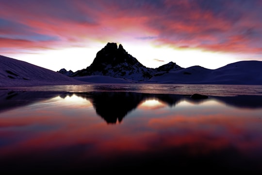 snow covered mountain near lake during sunset in Pic du Midi d'Ossau France