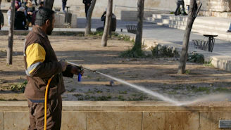 man in brown jacket holding black and gray stick