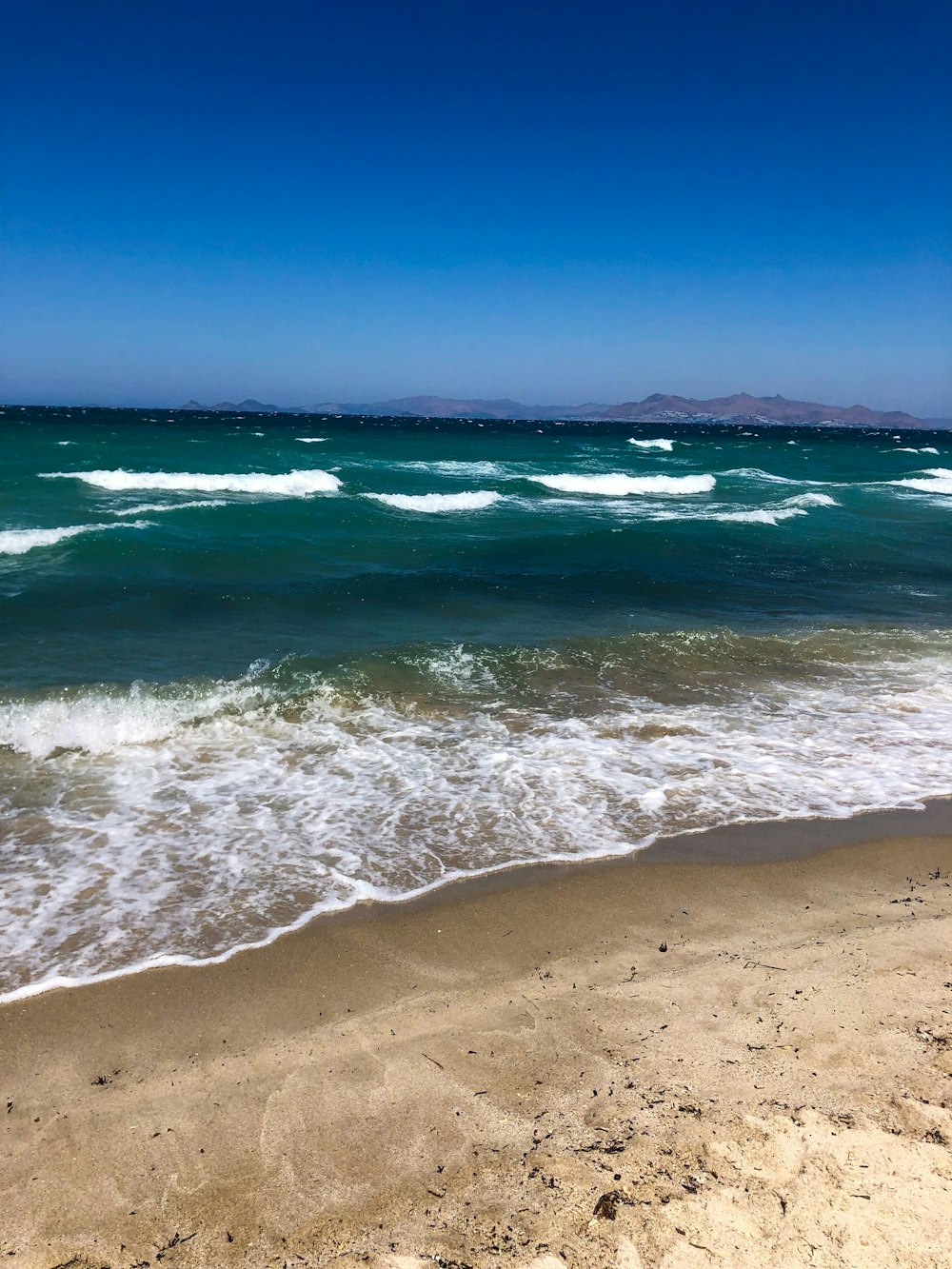 sea waves crashing on shore during daytime