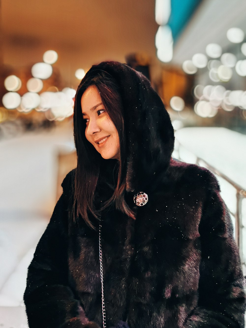 woman in black fur coat standing on snow covered ground during daytime