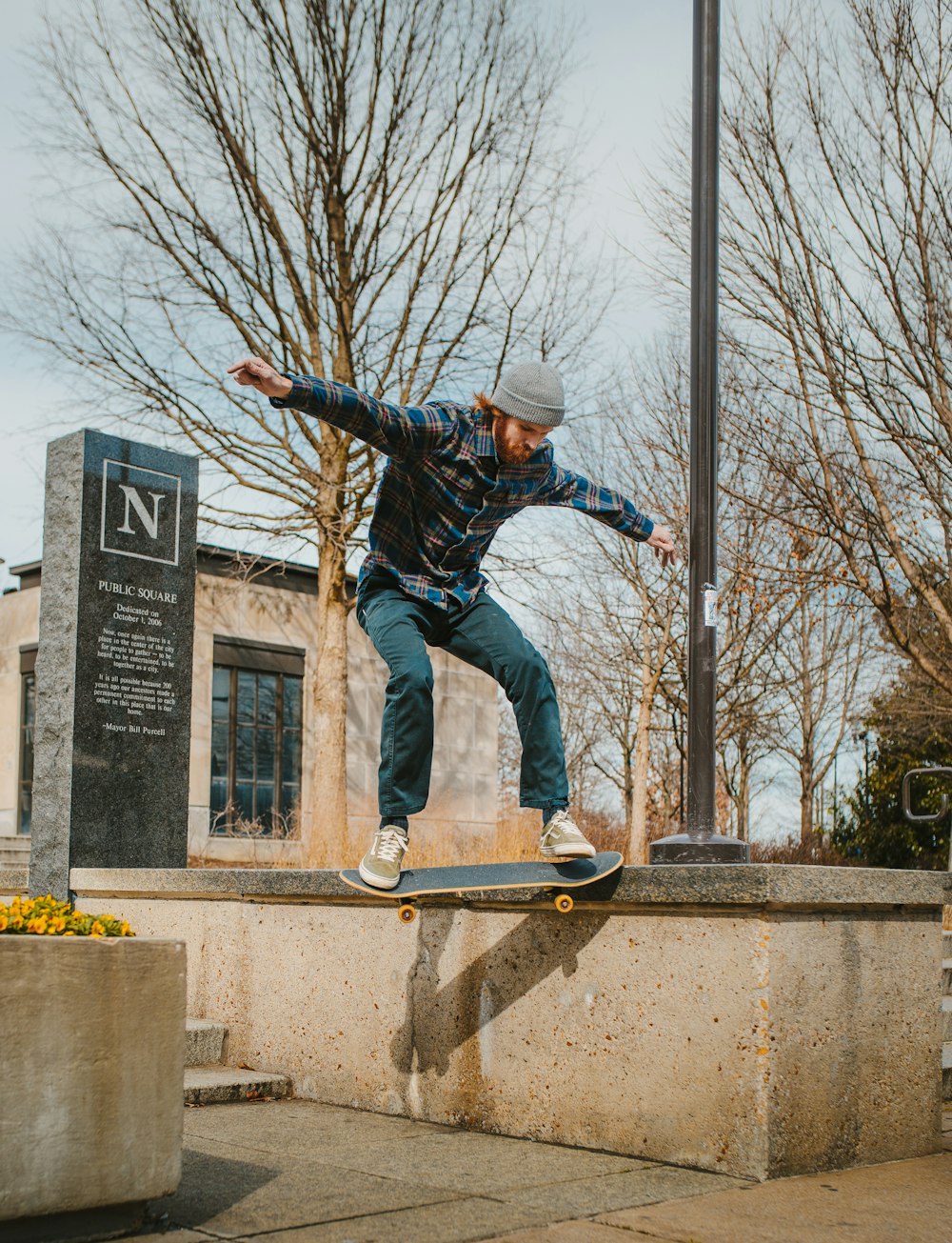 man in blue jacket and blue denim jeans jumping on yellow and gray metal railings during