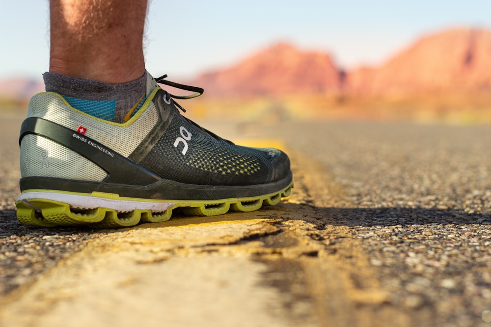 person wearing black and yellow nike running shoes