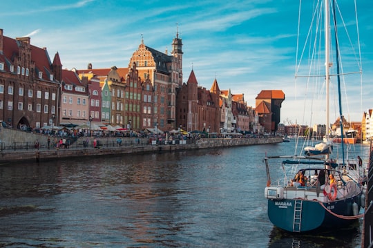 white boat on water near buildings during daytime in Medieval Port Crane Poland