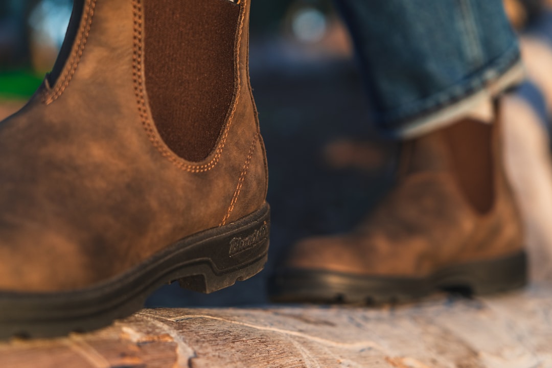 person wearing brown leather boots