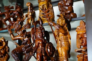 Intricately crafted spiritual collectibles showcased on a wooden shelf.