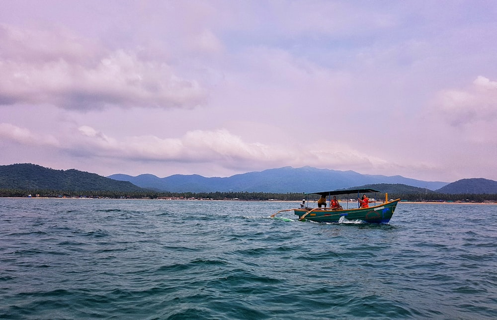 brown boat on sea under white clouds during daytime