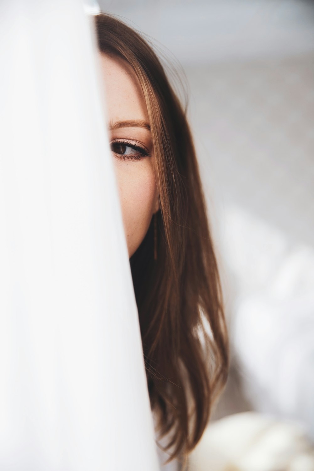 woman in white shirt leaning on white textile