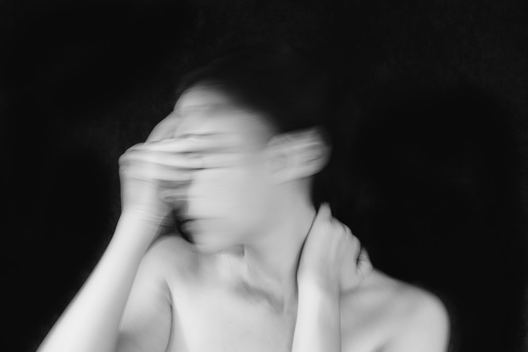 grayscale photo of topless woman covering her face