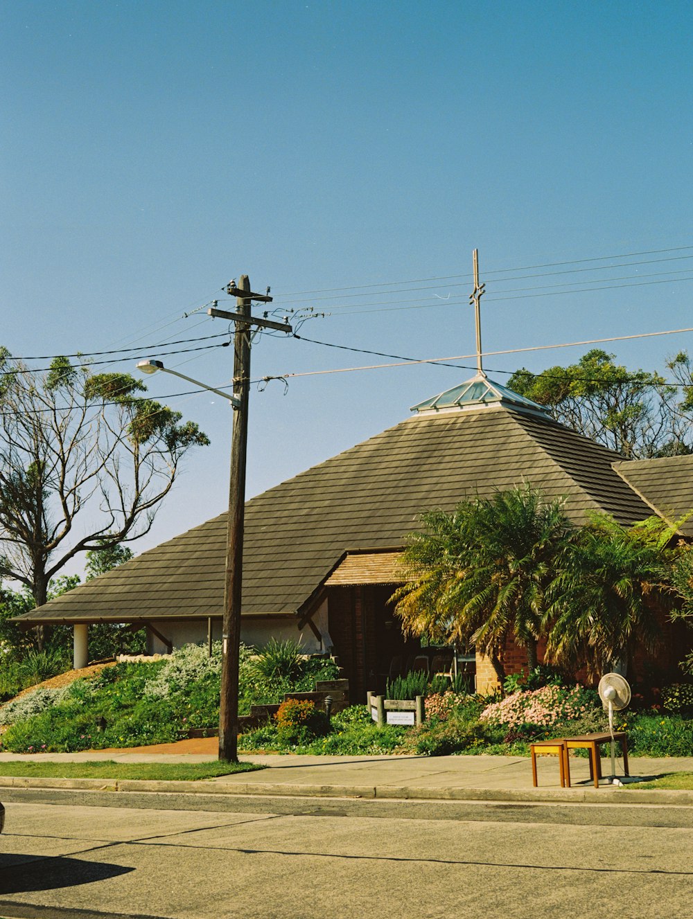 brown and white house near green trees under blue sky during daytime