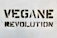 Bold black stencil text reading 'VEGANE REVOLUTION' is spray-painted on a textured white wall.