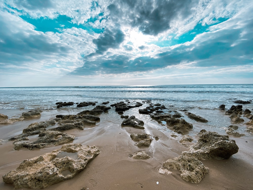 sea waves crashing on shore under blue and white cloudy sky during daytime