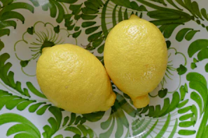 Golden lemon pickles arranged artfully on a cream-colored ceramic plate.