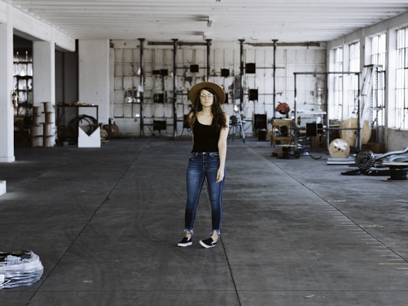 Technician in uniform inspecting equipment inside a spacious warehouse.
