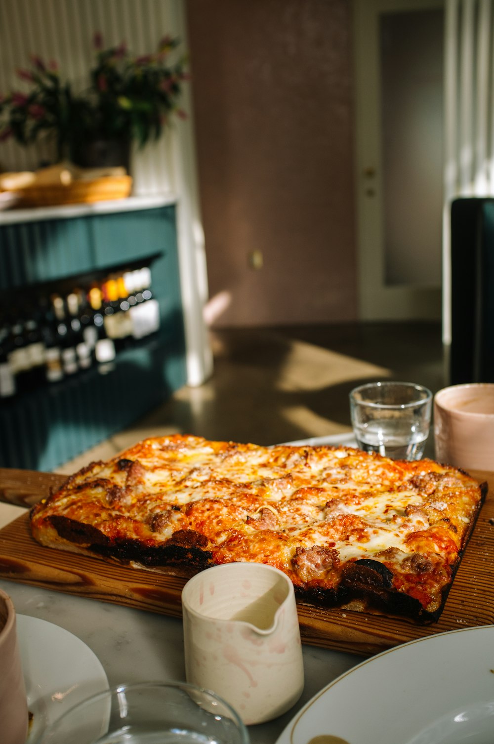 pizza on white ceramic plate beside clear drinking glass