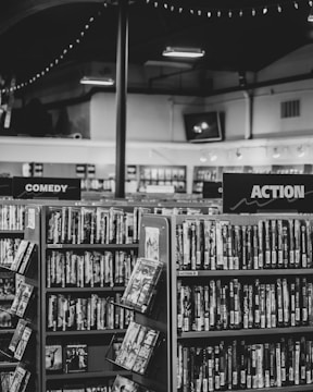 grayscale photo of books on shelves