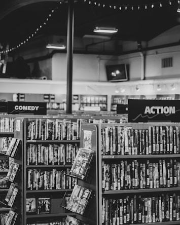 grayscale photo of books on shelves