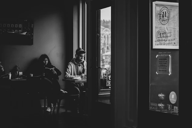 Portrait of Dominik Grill writing notes in a cozy café in Colombia with a minimalist background.