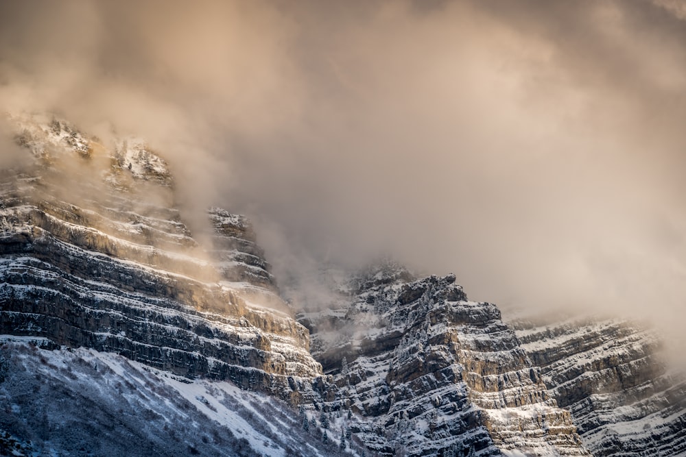 snow covered mountain under cloudy sky