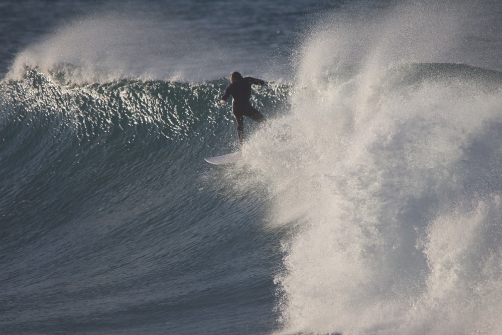 Homme surfant sur les vagues de la mer pendant la journée