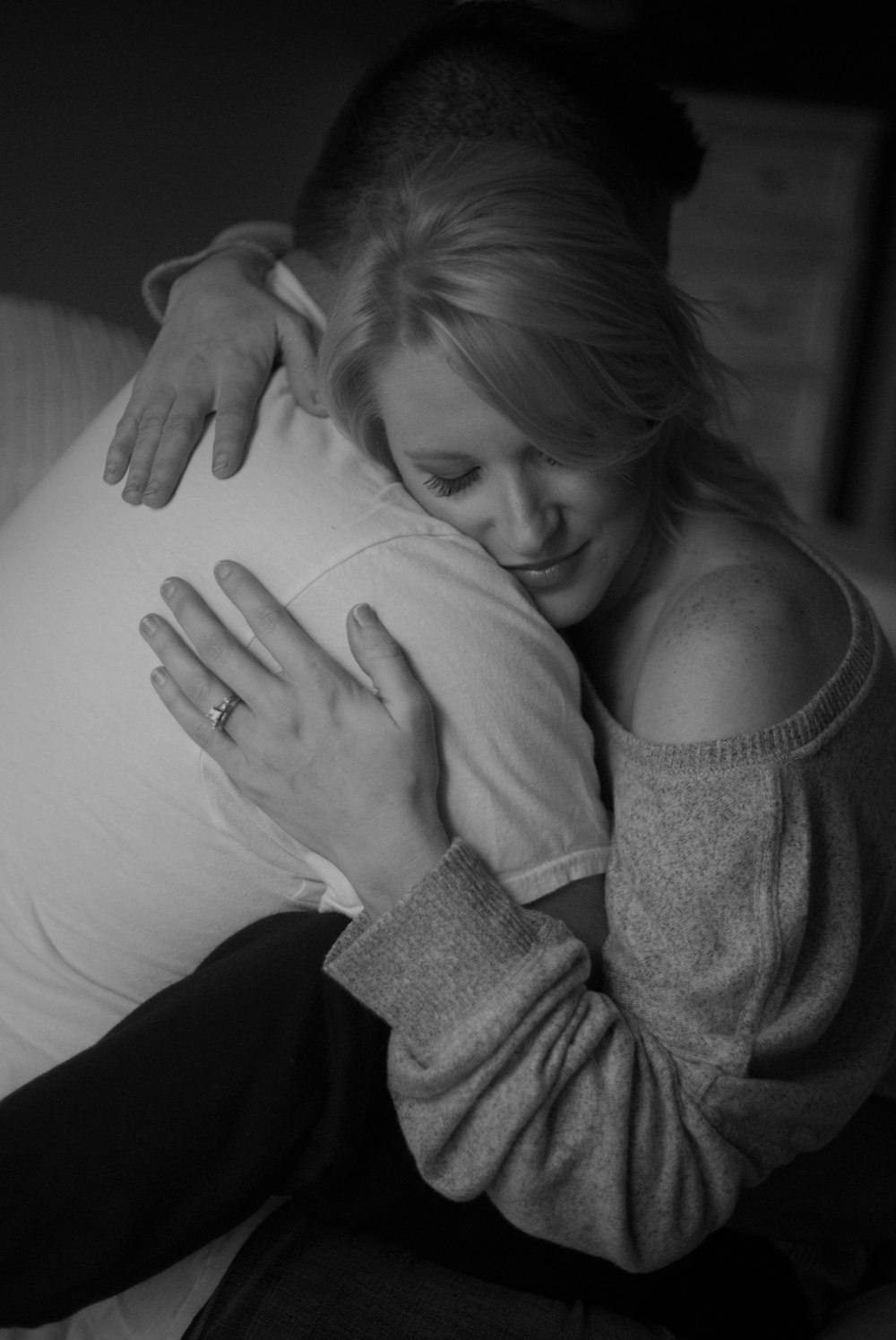 woman in gray sweater lying on bed