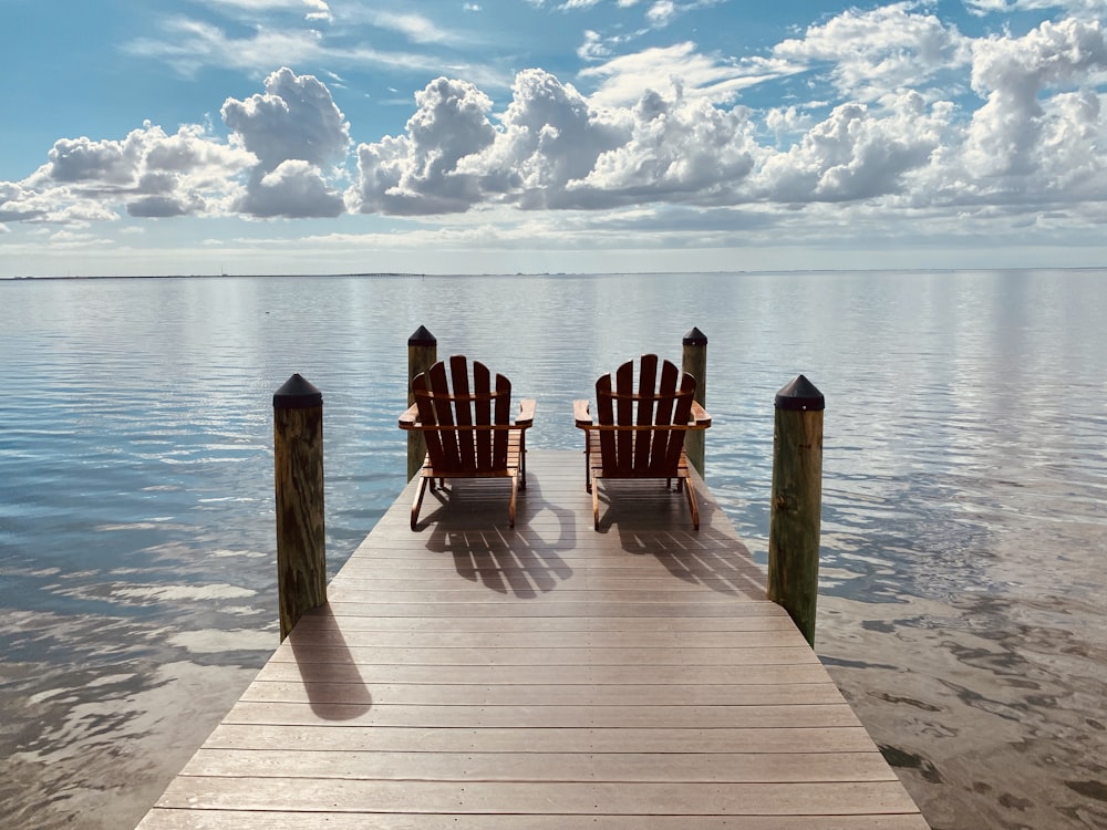 brown wooden dock on sea under blue sky during daytime