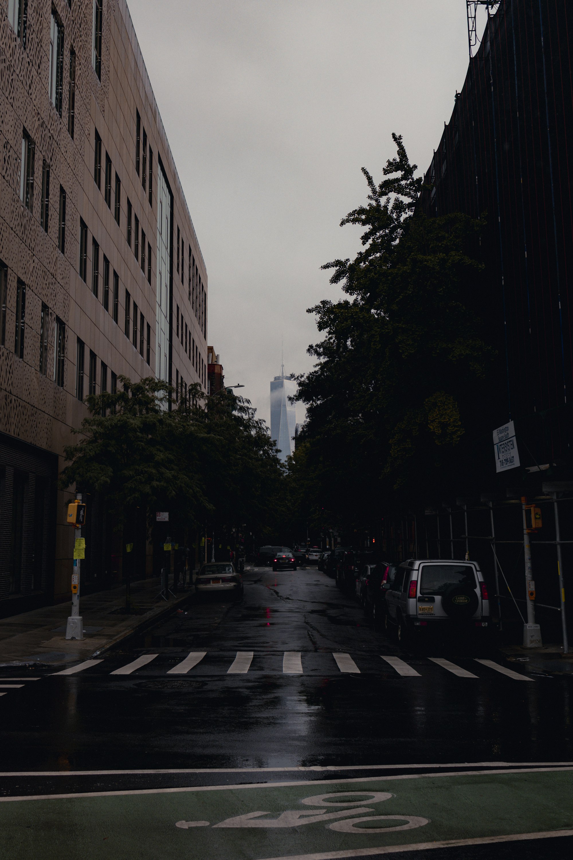 cars parked on side of the road in between buildings