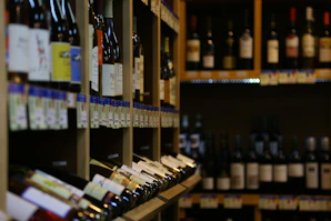 Rows of wine bottles with elegant labels arranged on wooden shelves.