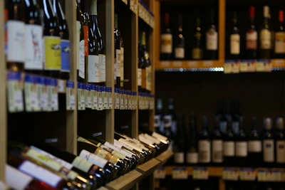 Rows of wine bottles with elegant labels arranged on wooden shelves.