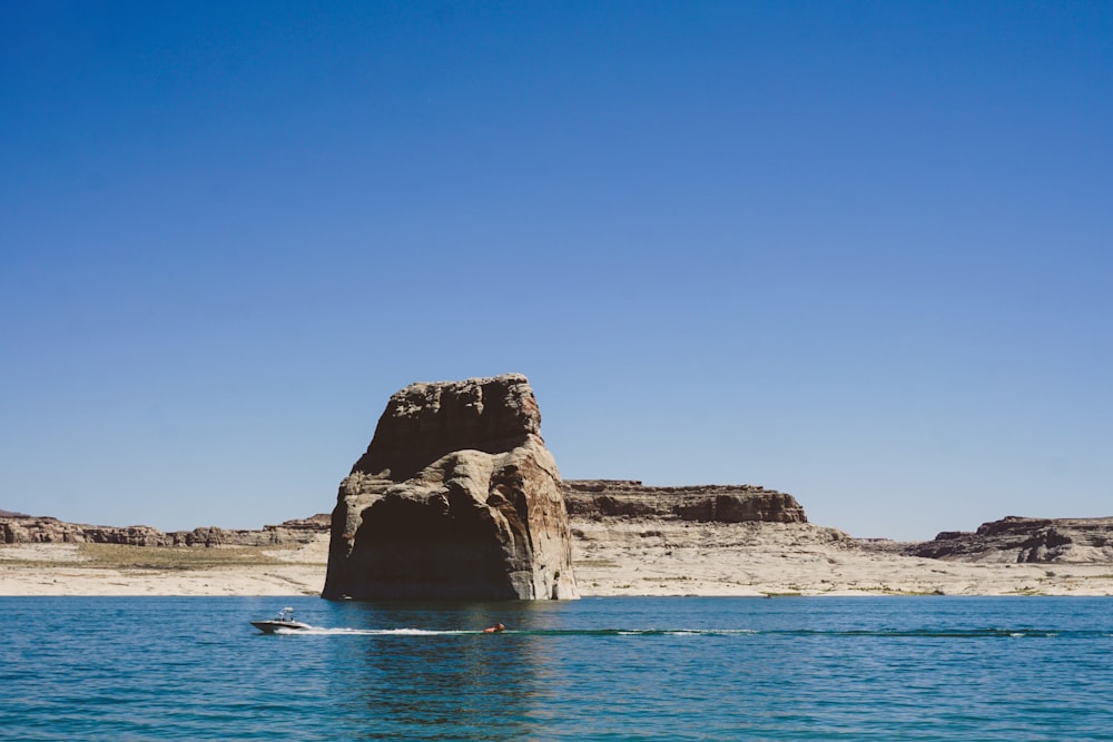 brown rock formation on blue sea under blue sky during daytime