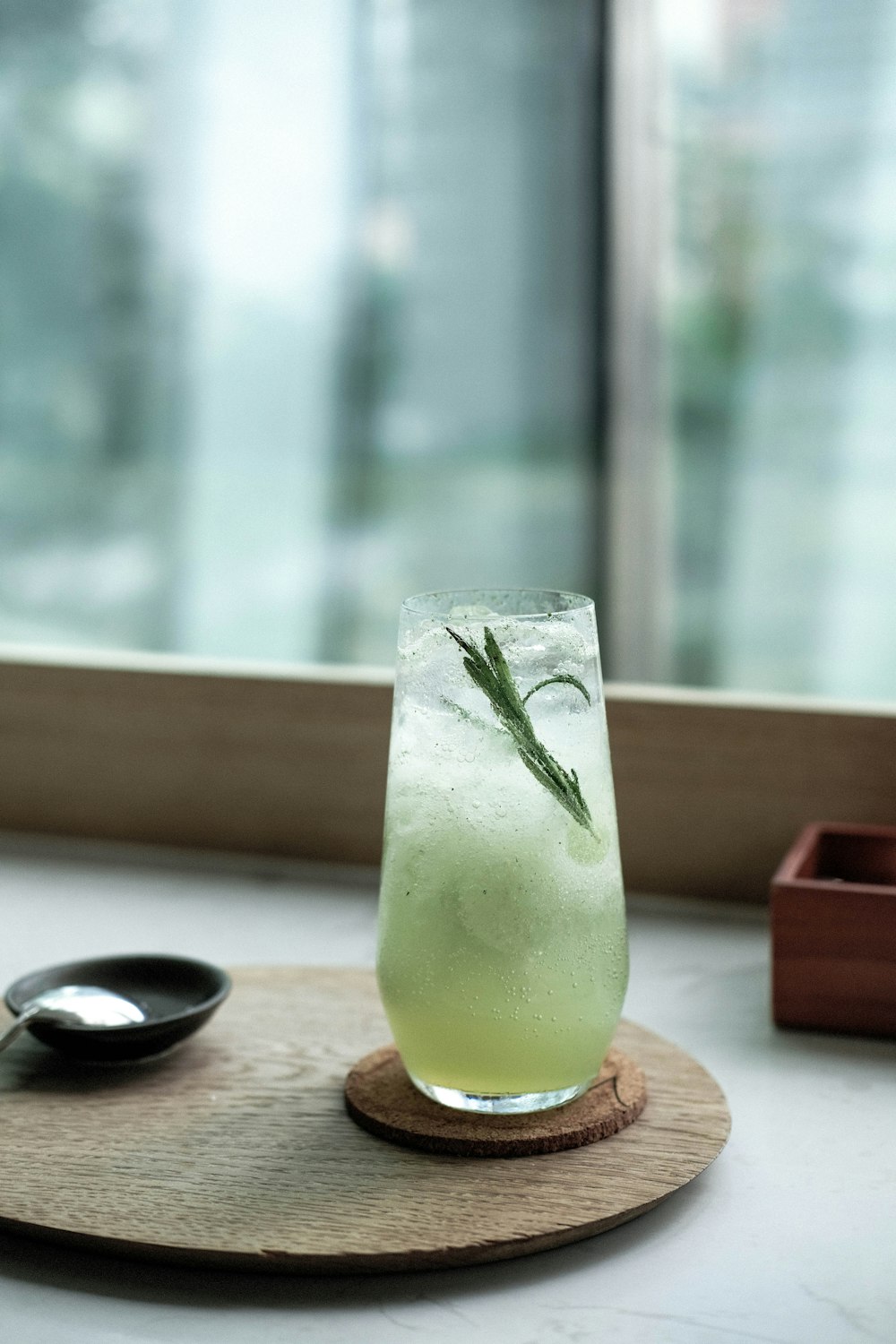 Bicchiere trasparente con liquido verde su tavolo di legno marrone