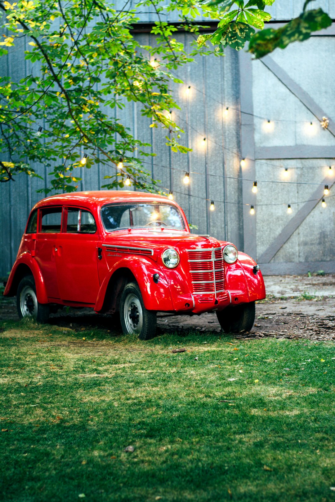 red vintage car parked on green grass field