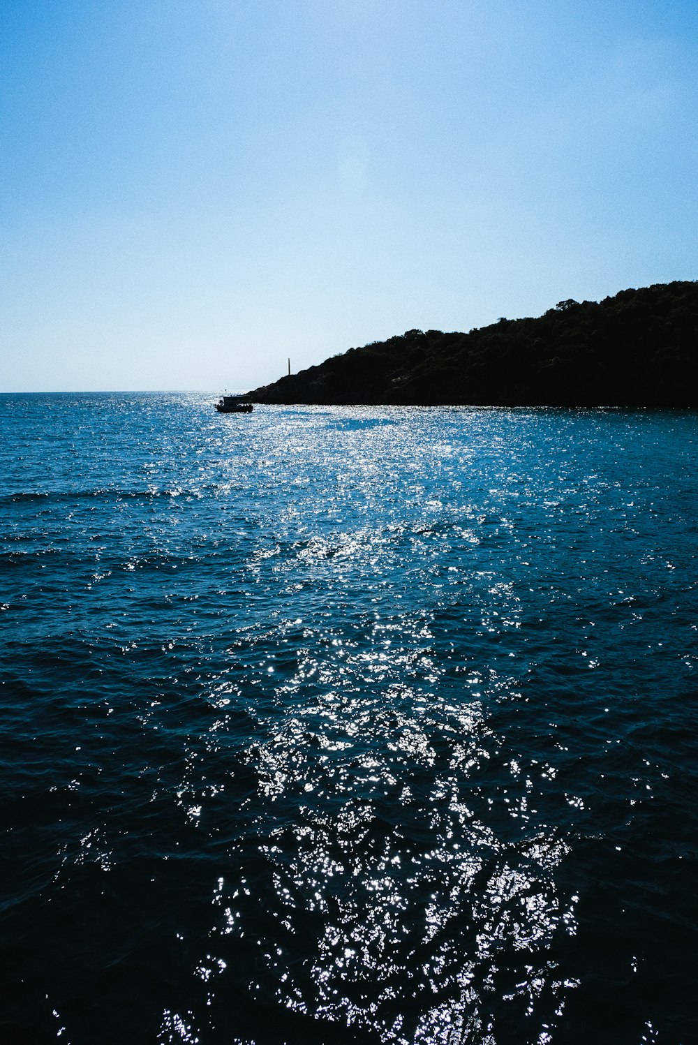 body of water near mountain during daytime