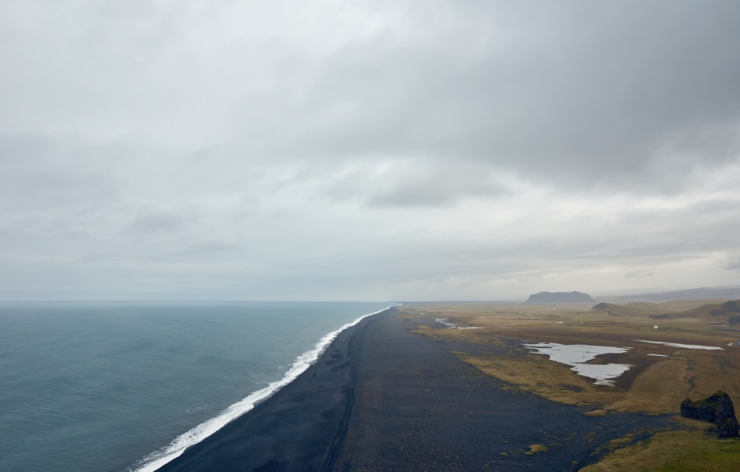 gray sand beach under gray cloudy sky