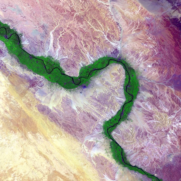 A satellite view of a river through a desert, with a thin strip of green along the river.