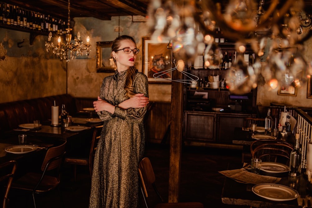 woman in brown and white coat standing near brown wooden table