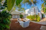 An inviting outdoor seating area surrounded by tropical plants and flowers.