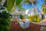 Outdoor lanai renovation with tropical plants and comfortable seating.