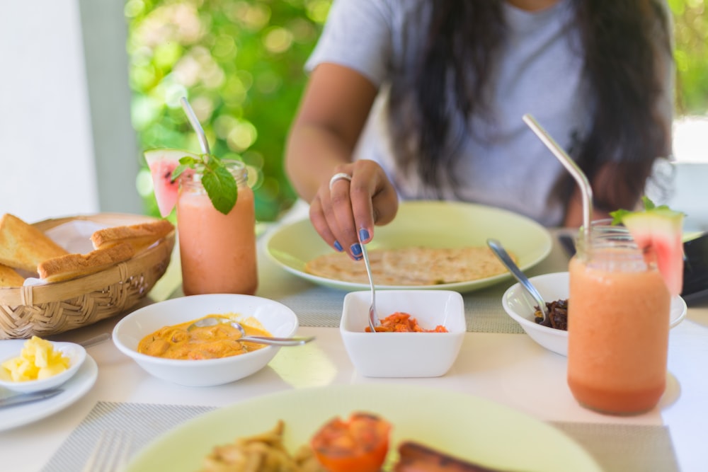 person holding silver fork and knife slicing a vegetable on white ceramic plate