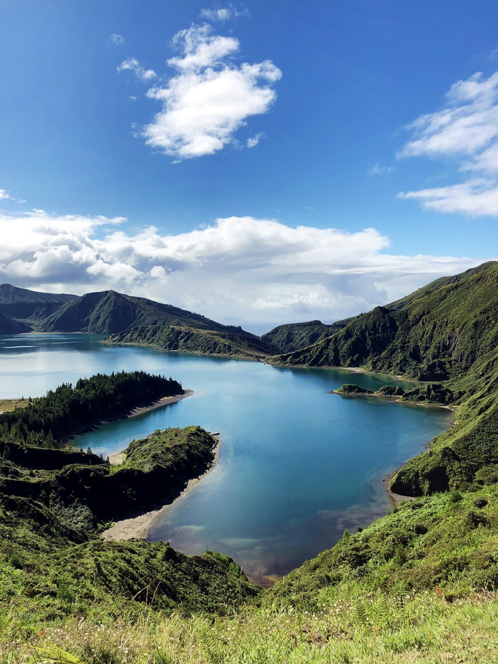 lake in the middle of mountains under blue sky