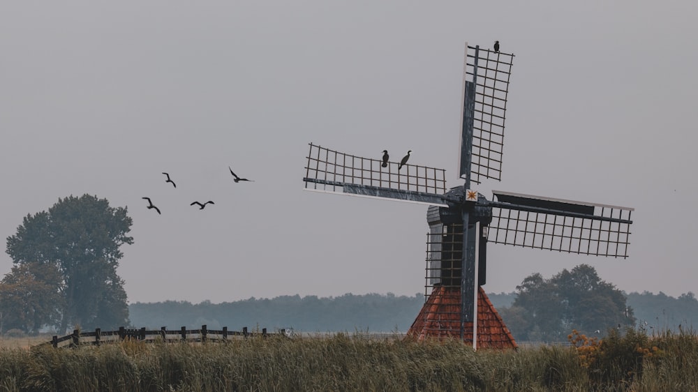 red and gray windmill on green grass field during daytime