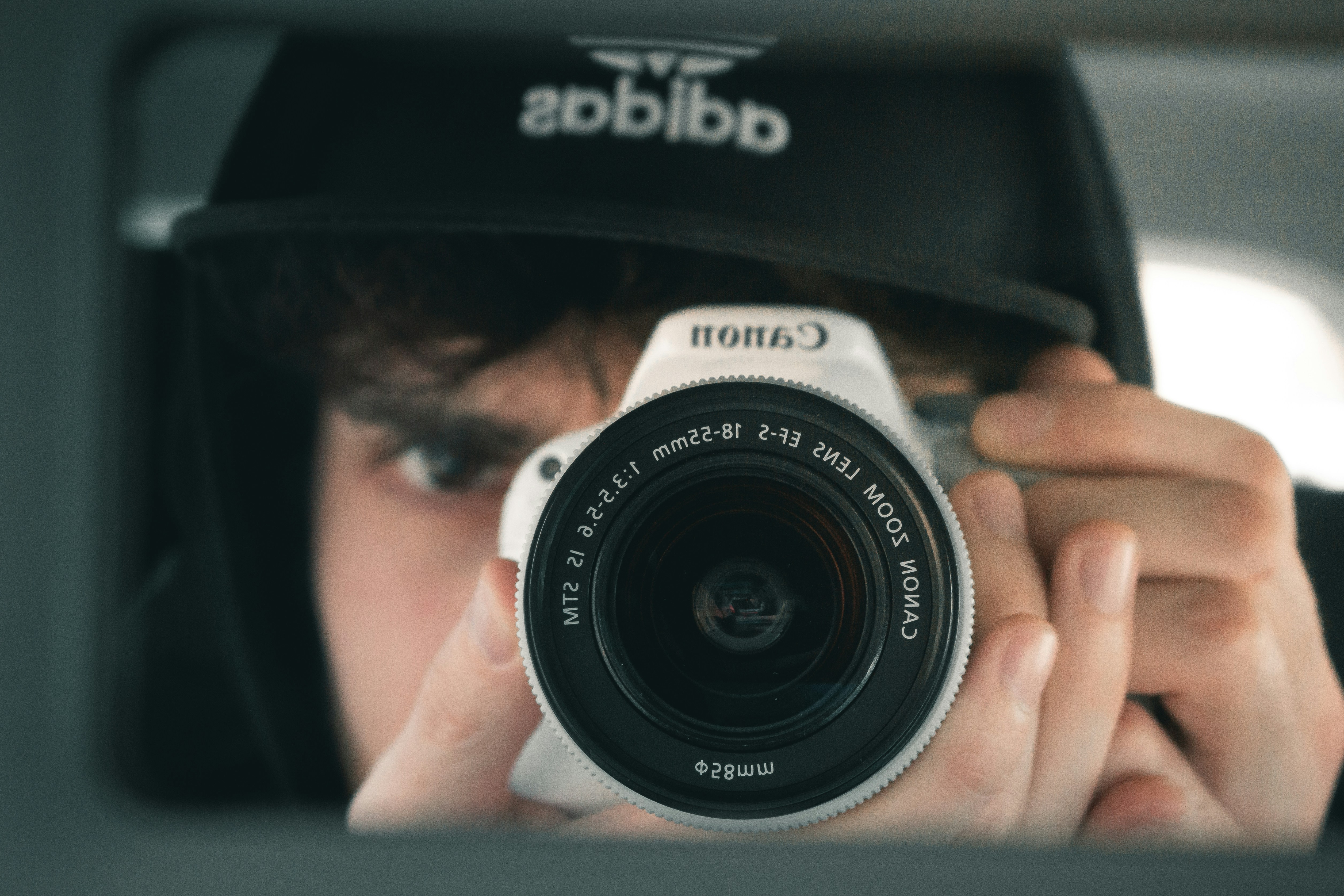 Man shooting with a canon camera in a mirror