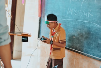man in brown button up shirt holding black smartphone