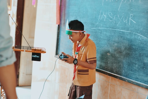 man in brown button up shirt holding black smartphone