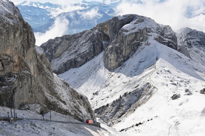 A scenic mountain train winding through snow-capped peaks.