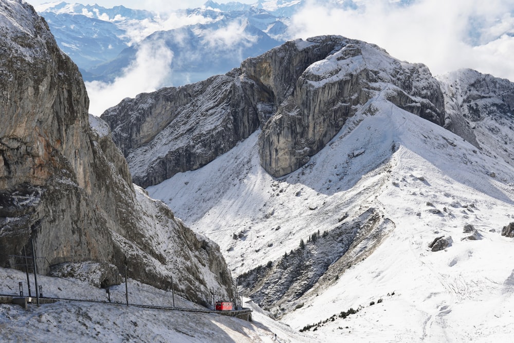 Auto nera sulla strada vicino alla montagna coperta di neve durante il giorno