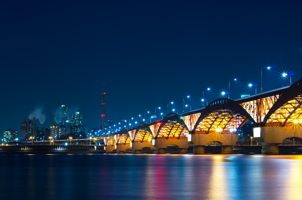 lighted bridge over water during night time